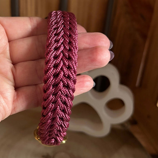weinrotes kleines Hundehalsband handgemacht wird in der Hand gehalten