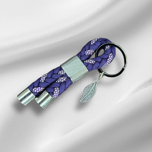 Schlüsselanhänger aus Paracord in lila mit einer silberenen schlaufe und ein silbernes Blatt als Anhänger