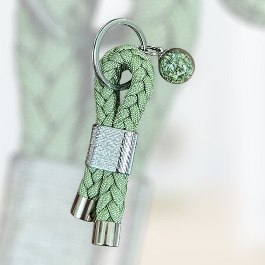 SChlüsselanhänger aus Paracord in grün mit einer solberen schlaufe und einer kleinen Glaskugel als Anhänger